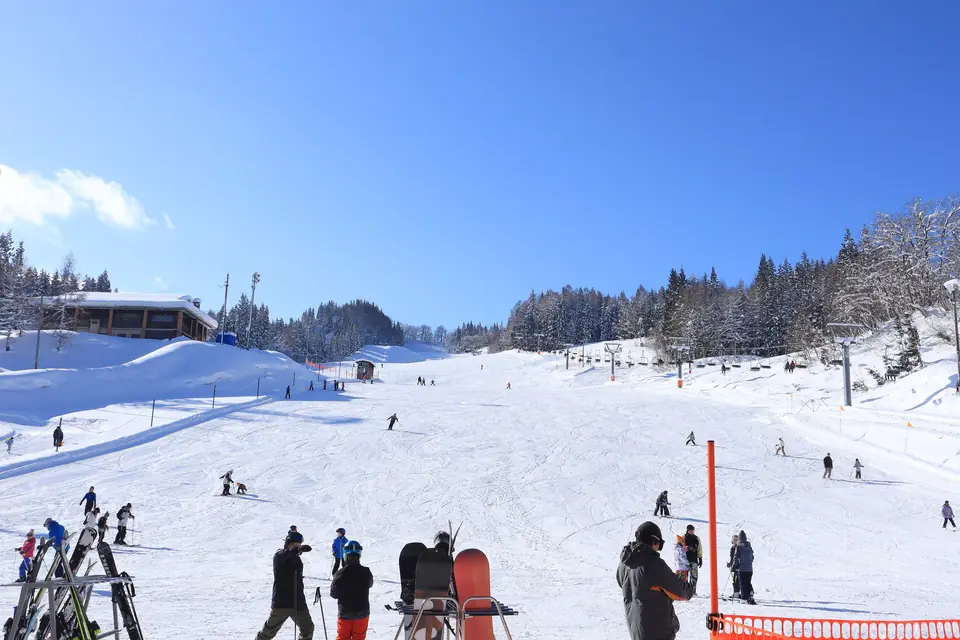 Skiers and snowboarders on a sunny ski slope
