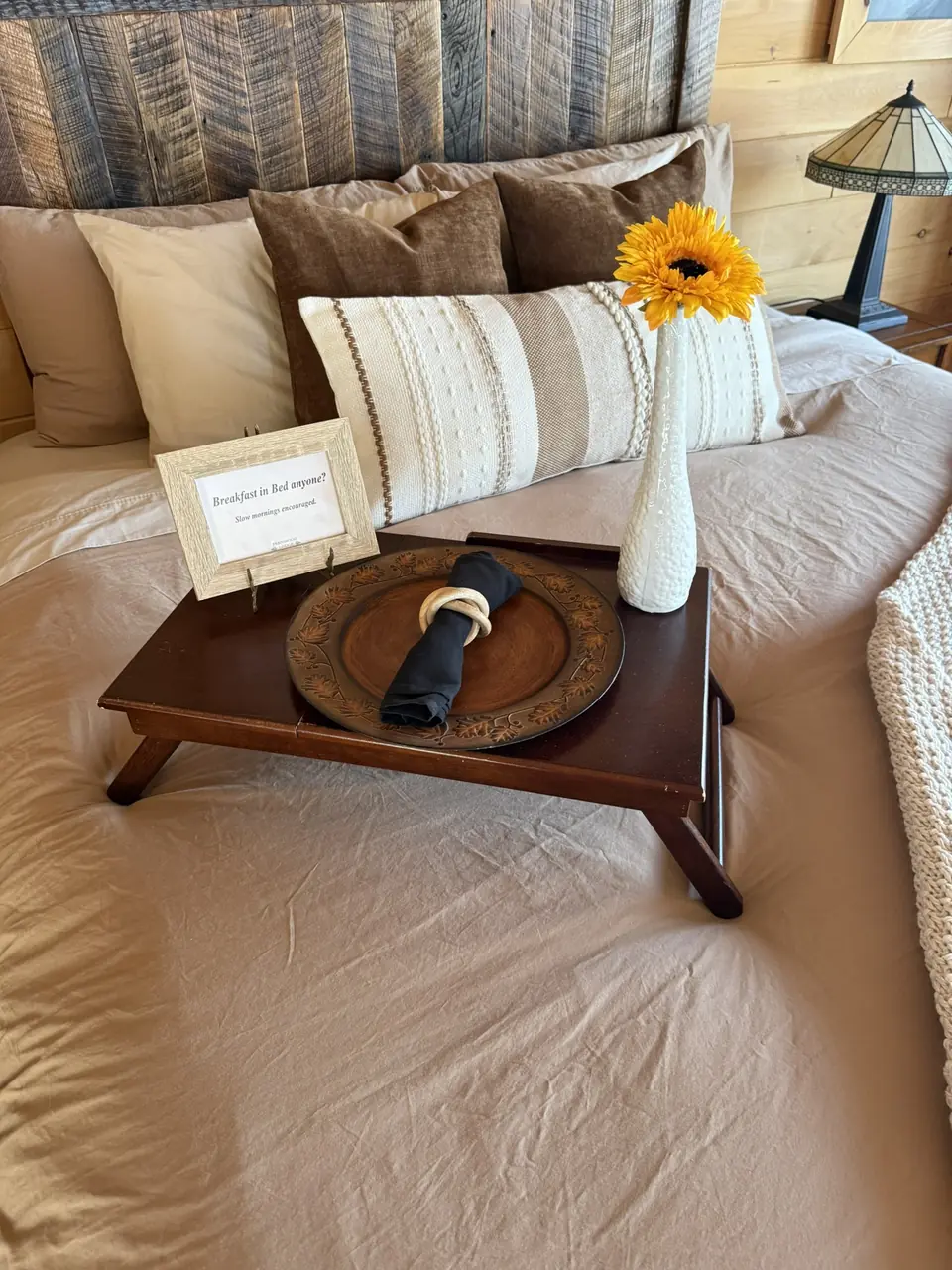 Made bed with a welcome tray and sunflower