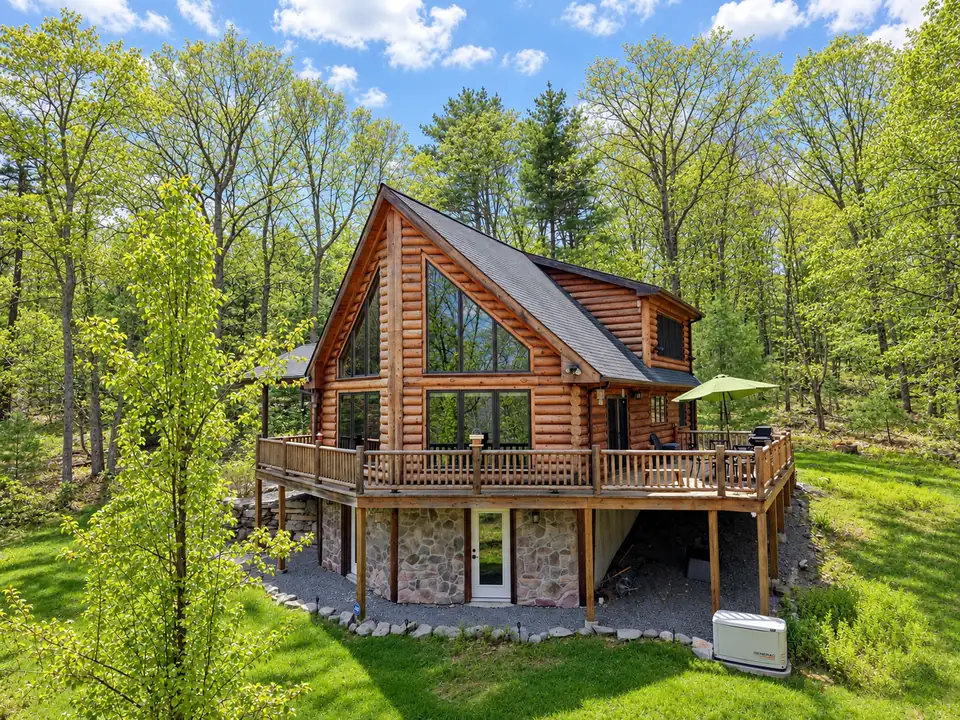Aerial view of the Fernwood Lodge log cabin in fresh spring green