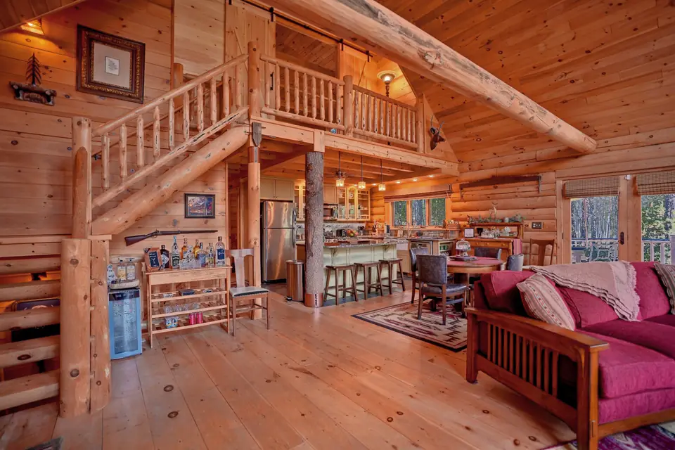 Open great room under the loft with sofas, dining area, and kitchen