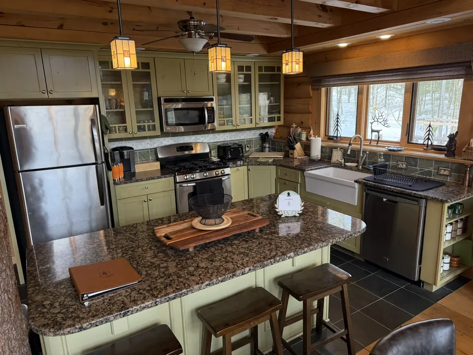 Fully equipped kitchen with granite counters, stainless appliances, and bar seating