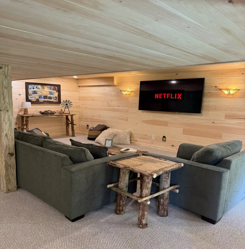 Lower level family room with sectional seating and a wall mounted TV