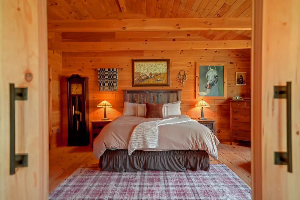 Primary suite with king bed, framed by open barn doors