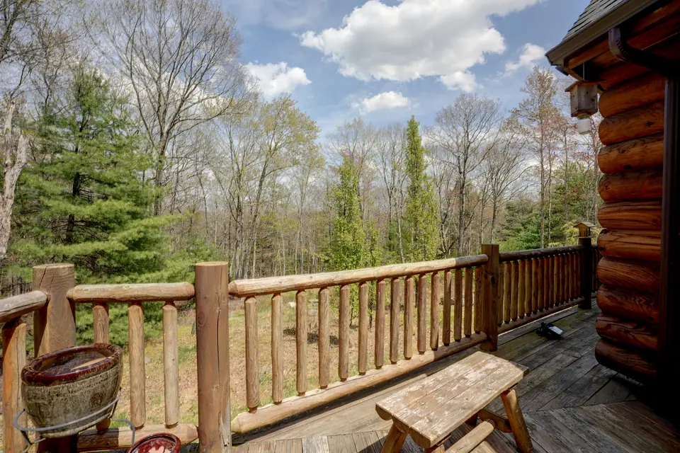 Log deck railing looking out over the spring woods