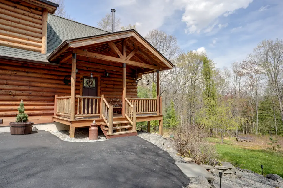 Covered front porch and log steps in spring